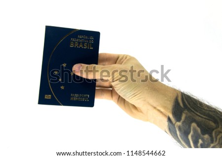 
long-sleeved tattoo hand holding a passport document
