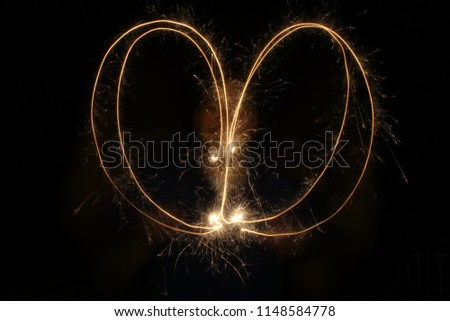 Low shutter speed of a sparkler in a shape of a heart
