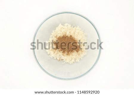 Chopped onions in a deep bowl. For spices added spices: black pepper, cumin, coriander. White background. Close-up. View from above.