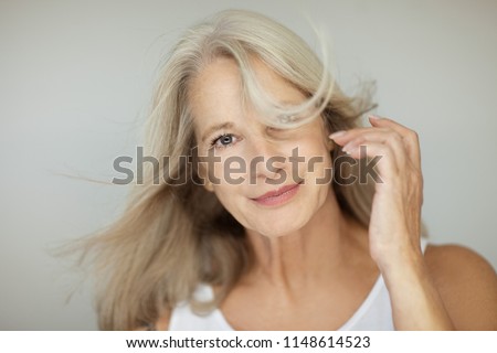 stunning beautiful and self confident best aged woman with grey hair smiling into camera, portrait with white background Royalty-Free Stock Photo #1148614523