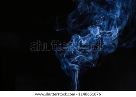 Blue swirling smoke abstract close up on black background