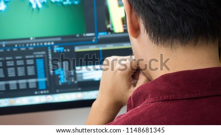 Male Videographer Edits and Cuts Footage and Sound on His Personal Computer.Shift focus Royalty-Free Stock Photo #1148681345