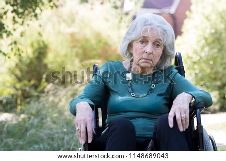 Depressed Senior Woman In Wheelchair Sitting Outdoors Royalty-Free Stock Photo #1148689043