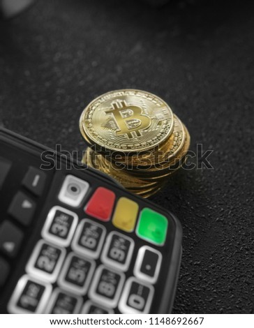 A pile of gold Bitcoin coins and POS terminal. Bitcoins Cryptocurrency. E-commerce, business, finance concept, banking and paymant.