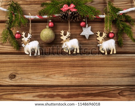 Deers, Christmas tree decor, fir branches on a wooden background. Festive background with space for text.