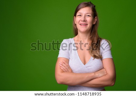 Young beautiful woman against green background