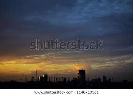 Silhouette of the modern buildings under colorful sky background. Bangkok city in sunset light. Cityscapes, office building, condominiums and hotels in business area in the evening. Subject not focus.