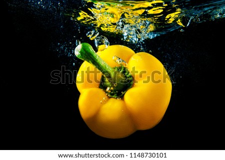 Yellow fresh vibrant pepper under water with reflection