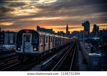 Subway train in New York at sunset and Manhattan cityscape view Royalty-Free Stock Photo #1148732384