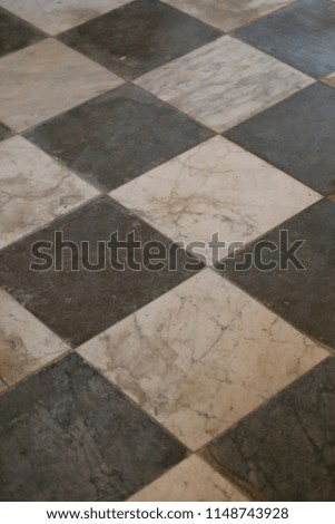 Close up interior view from above of the floor of a church made of black and white tiles. Abstract architectural image with a geometric surface composed of crossing lines and squares. Graphic picture.