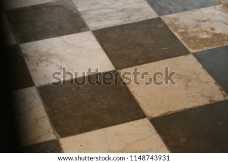 Close up interior view from above of the floor of a church made of black and white tiles. Abstract architectural image with a geometric surface composed of crossing lines and squares. Graphic picture.