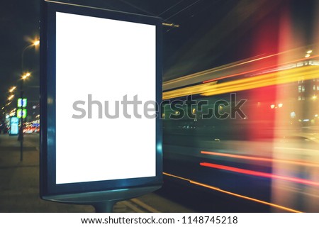 Blank white lightbox at night. Mock-up design concept. Car lights in motion blur