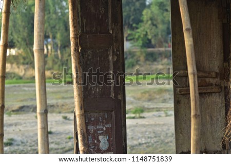 A broken door of a house of a rural village isolated unique blurry photo
