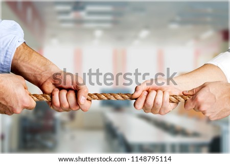 Business people pulling rope in opposite directions Royalty-Free Stock Photo #1148795114