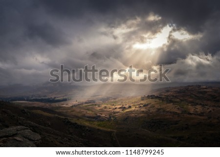 This amazing place is taken in Otago of New Zealand. It was a very cloudy day. The sun magically shines through a gap through the cloud producing amazing sun ray in the sky. It looks surreal. Royalty-Free Stock Photo #1148799245