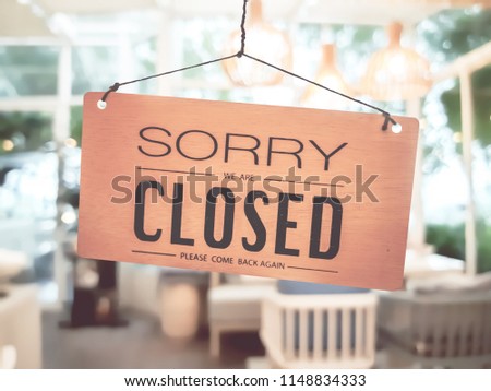 Business coffee cafe shop sign board is hang on door and show "Sorry We are Closed" with cafe and resturant blur bokeh background.