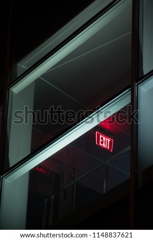 Exit sign in hallway viewed through window