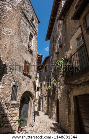 View of an alley with houses of the ancient stone made medieval town of Sermoneta, Italy. No people.