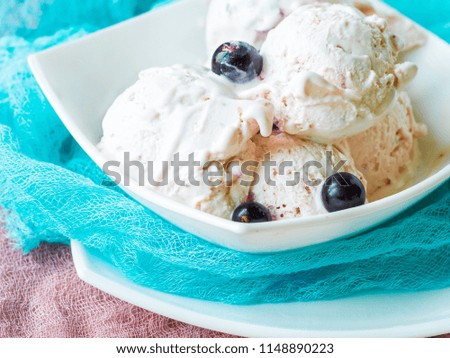 black currant ice cream on white square plate with bright blue and dark pink gauze. dilicious summer dessert