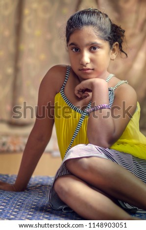 Beautiful Indian Asian Girl sitting and posing looking at camera front view Fashion Shot