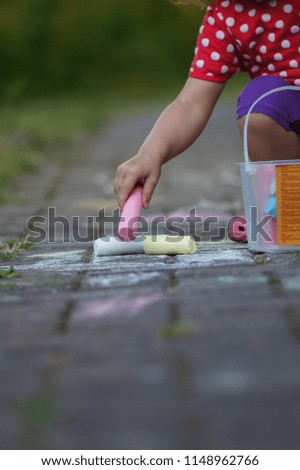 Children's art, drawing by chalk. The child paints with chalk on the asphalt.