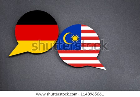 Germany and Malaysia flags with two speech bubbles on dark gray background