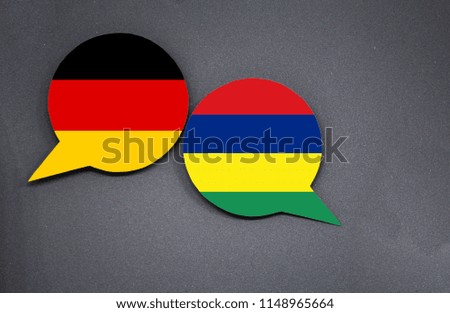 Germany and Mauritius flags with two speech bubbles on dark gray background