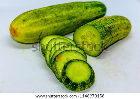 Cucumber and slices isolated over white background. Raw Food diet. Low angle view. Close up.