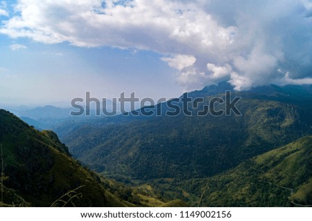 Mountain peaks in the jungle under the blue sky with white furry clouds. Sri Lanka. 2018