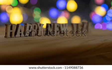 HAPPY NEW YEAR wooden letters with lights bokeh background. Selective focus.