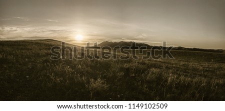 New day. Blinding sun. Sunrise in hills. Sun and hills. Sunrise in steppe. Dark gold. Dark sun. Dawn. Royalty-Free Stock Photo #1149102509