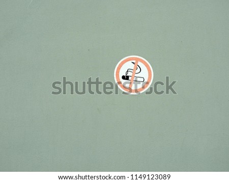  The sign-smoking is forbidden, pasted on the old wall painted in light green,   