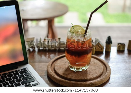 Special coffee, Orange juice and espresso shot and soda on the wooden table. With laptop.