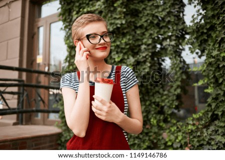  A woman with glasses is holding a glass.                              