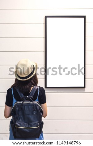 women looking to blank Photo frame on wood wall