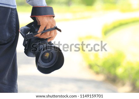 Photographer holding DSLR camera in his hands, Travel lifestyle vacations concept