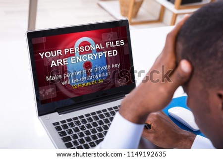 Worried Businessman Looking At Encrypted Text On The Laptop Screen In The Office