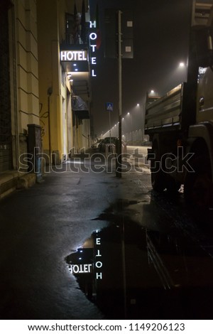 Hotel by night with rain and puddles