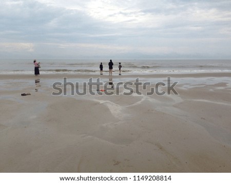 Tourists take pictures in the morning at the beach.