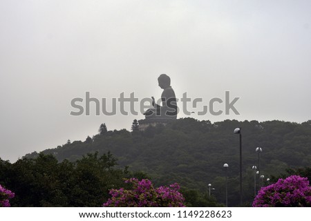 A distant Buddha on top of a mountain.
