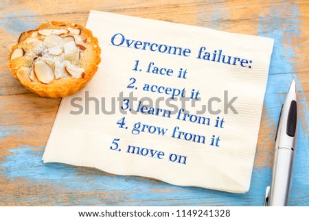 Overcome failure in five steps - handwriitng on a napkin with an almond cookie
