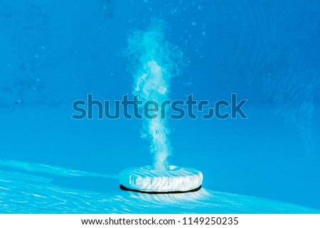 Top view of an active underwater discharge nozzle filtration system set in a blue liner swimming pool. Royalty-Free Stock Photo #1149250235