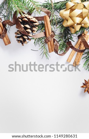 Christmas composition. Gift box, ribbon, fir branches, cones, anise, cinnamon on white background. Flat lay, top view, mock up copy space vertical