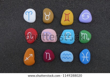 Astrological signs with stylized colored stones over black volcanic sand Royalty-Free Stock Photo #1149288020