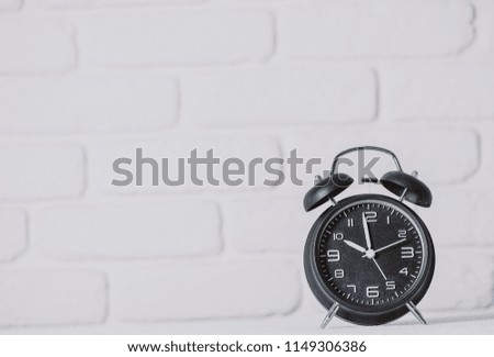 Stack of books with apple and alarm clock on blackboard background