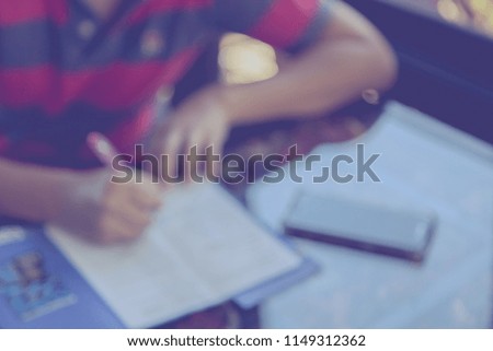 Blur image of man fill out application with camera and smart phone on the table background