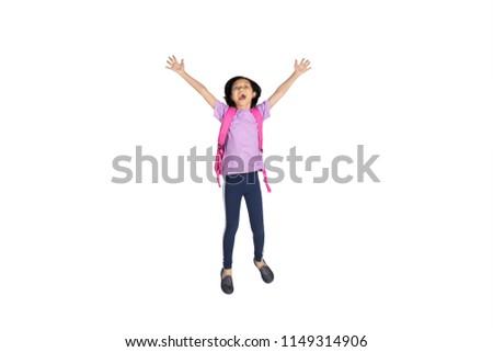 Picture of Asian schoolgirl looks happy while leaping on the studio, isolated on white background