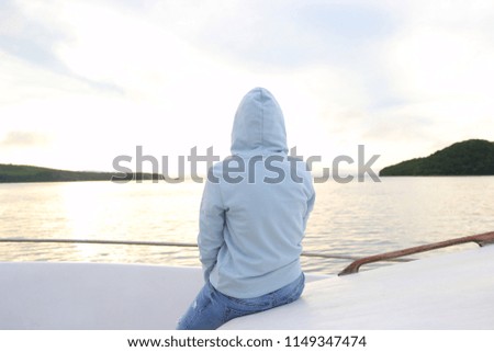 the girl on the boat looks at the sunset