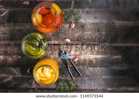 Jars of pickled fresh, homemade vegetables on a wooden background. Top view. Stock of food