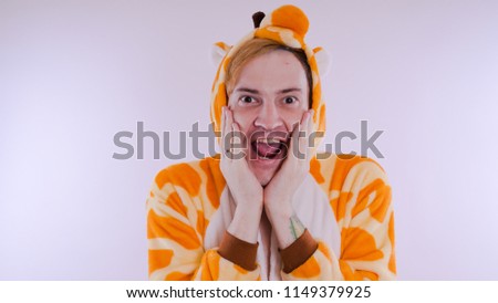 guy in a bright children's pajamas in the form of a kangaroo, on white background. emotional portrait of a student. costume presentation of children's animator.